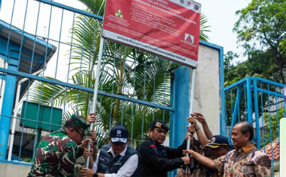 Pencabutan papan peringatan radiasi di salah satu pabrik yang telah didekontaminasi dari radiasi Cesium-137 di Kawasan Industri Cikande, Kabupaten Serang, Banten, Jumat (17/10/2025). (Antara/Muhammad Bagus)